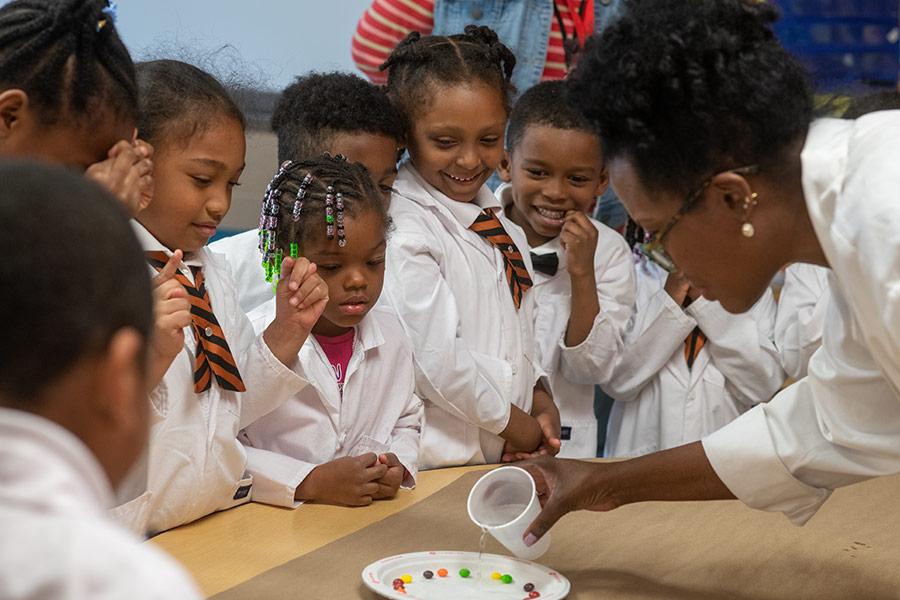 Group of children standing and watching a teacher